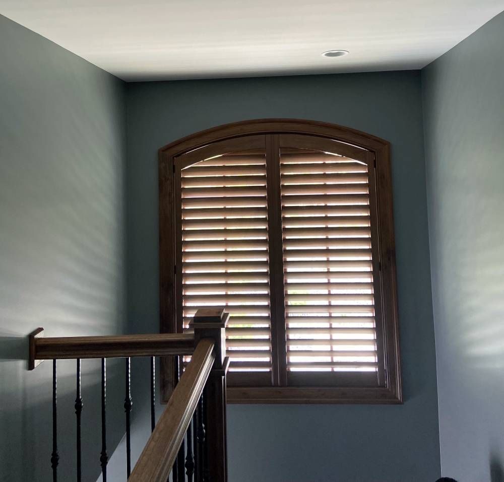 A staircase with a window with shutters on it