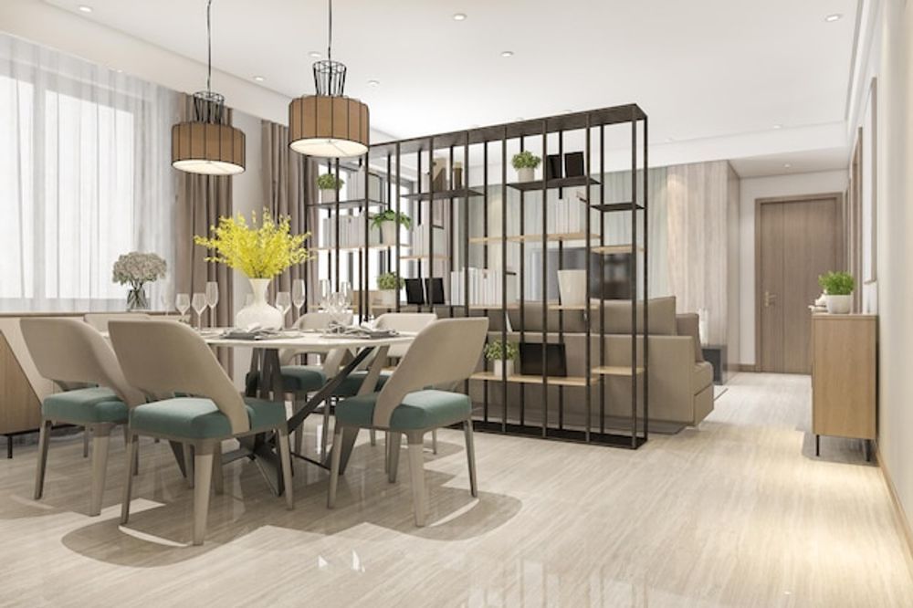 A modern dining area with a round table, teal-cushioned chairs, and a metal room divider separating it from a sofa.