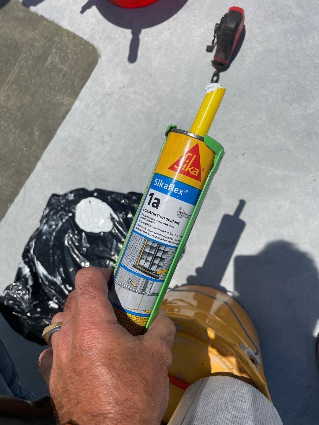 A person is holding a can of sika sealant