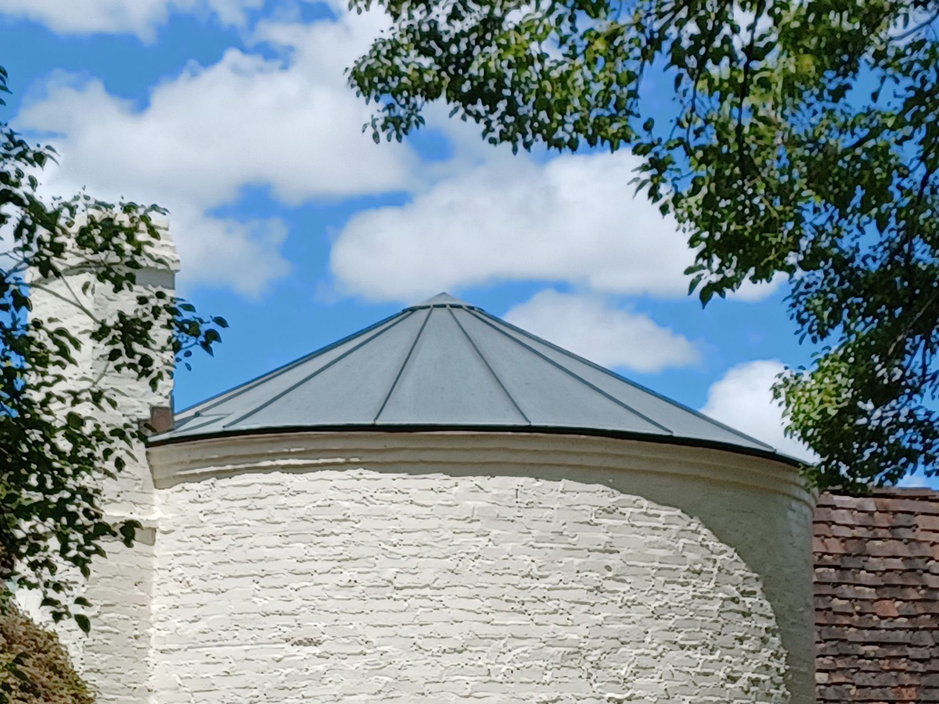 A white brick building with a metal roof