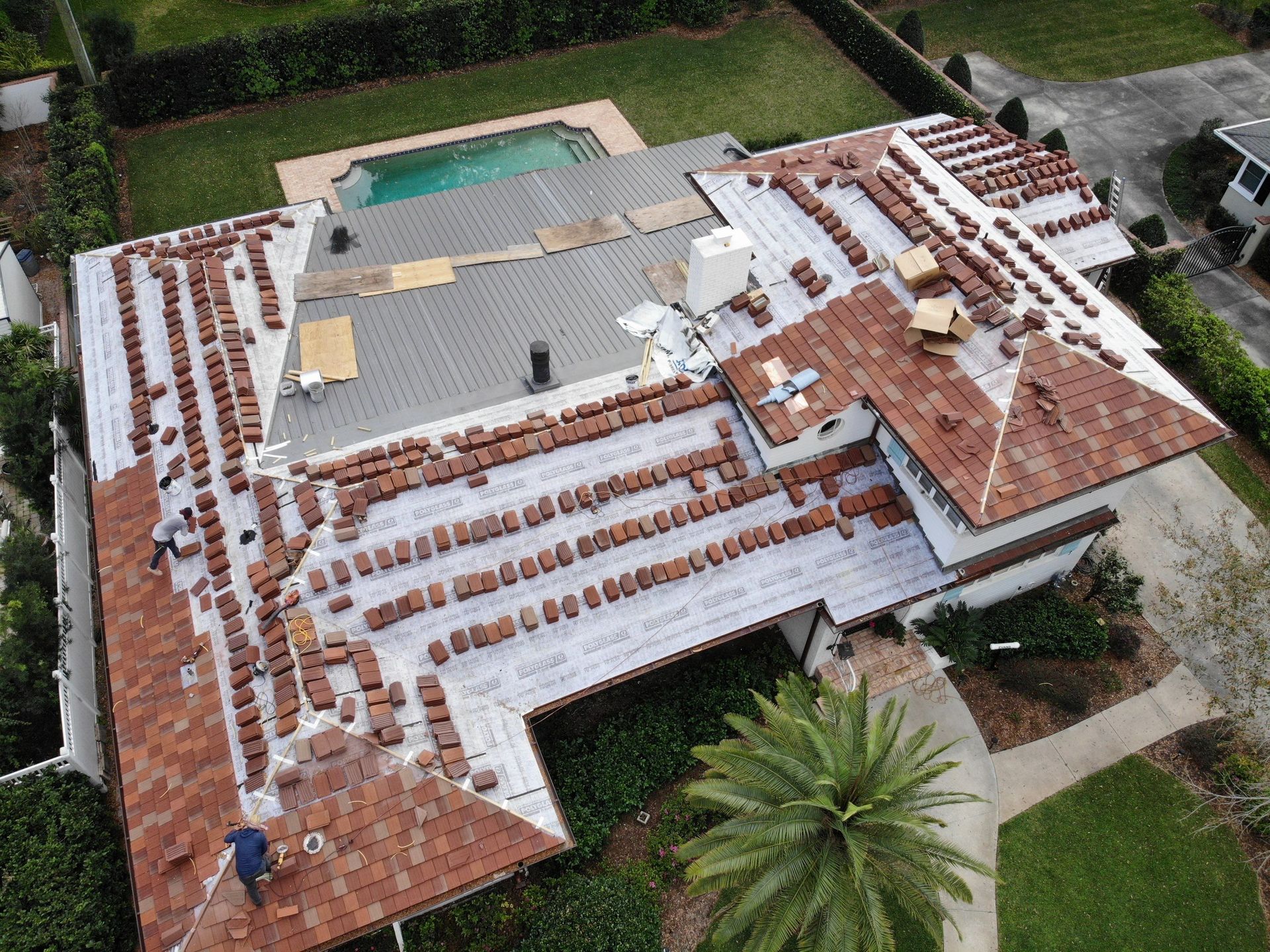 An aerial view of a house under construction with a pool in the backyard.