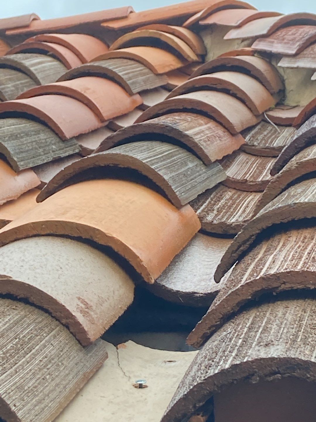 A close up of a roof with many different colored tiles