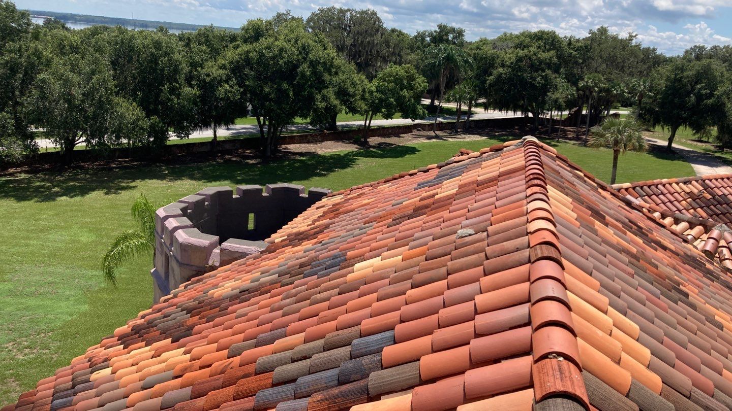 An aerial view of a tiled roof with trees in the background.
