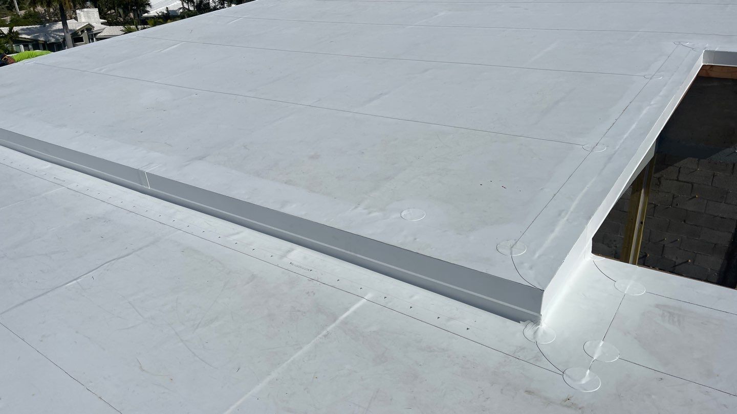 A close up of a white roof with a gutter on it.