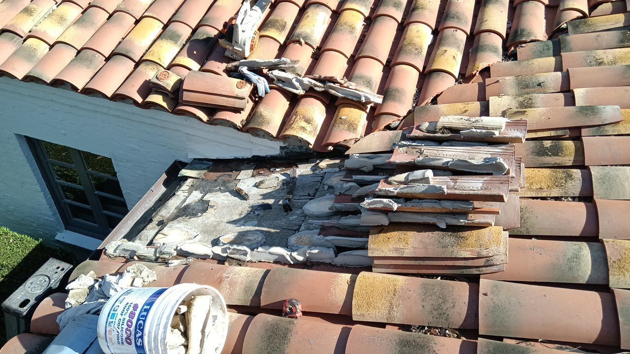 A bucket of water is sitting on the roof of a house.