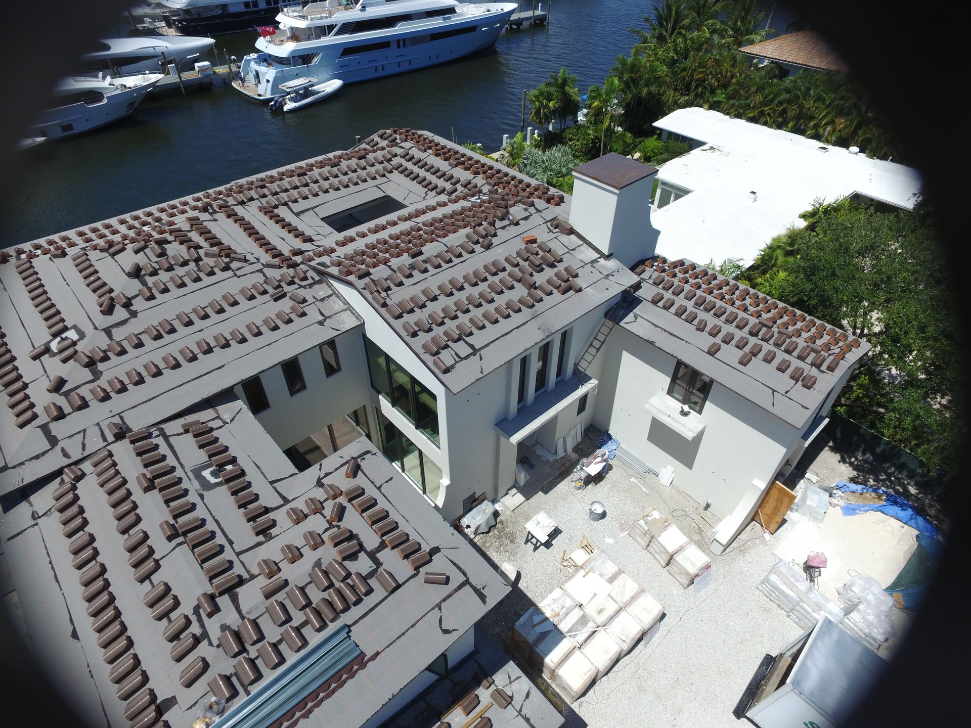 An aerial view of a large house with a large boat in the background