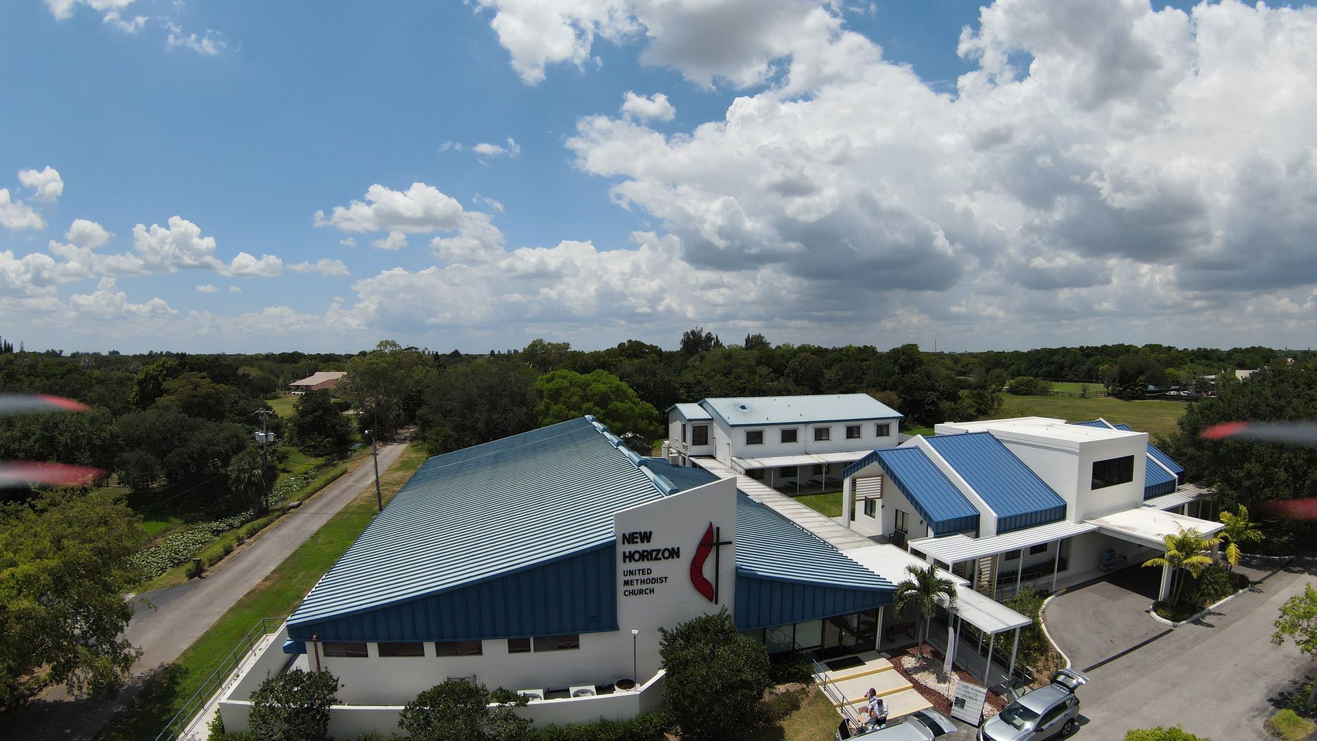 An aerial view of a large building with a blue roof