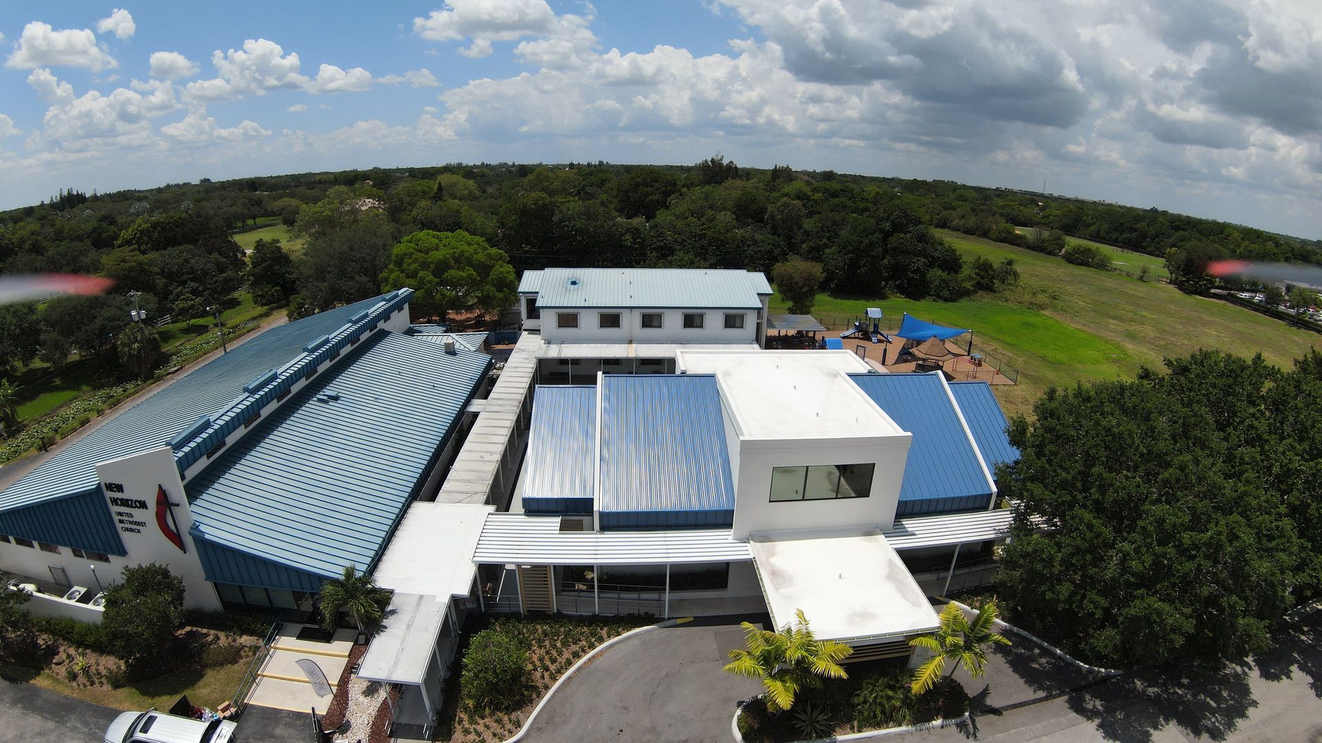 An aerial view of a large building with a blue roof
