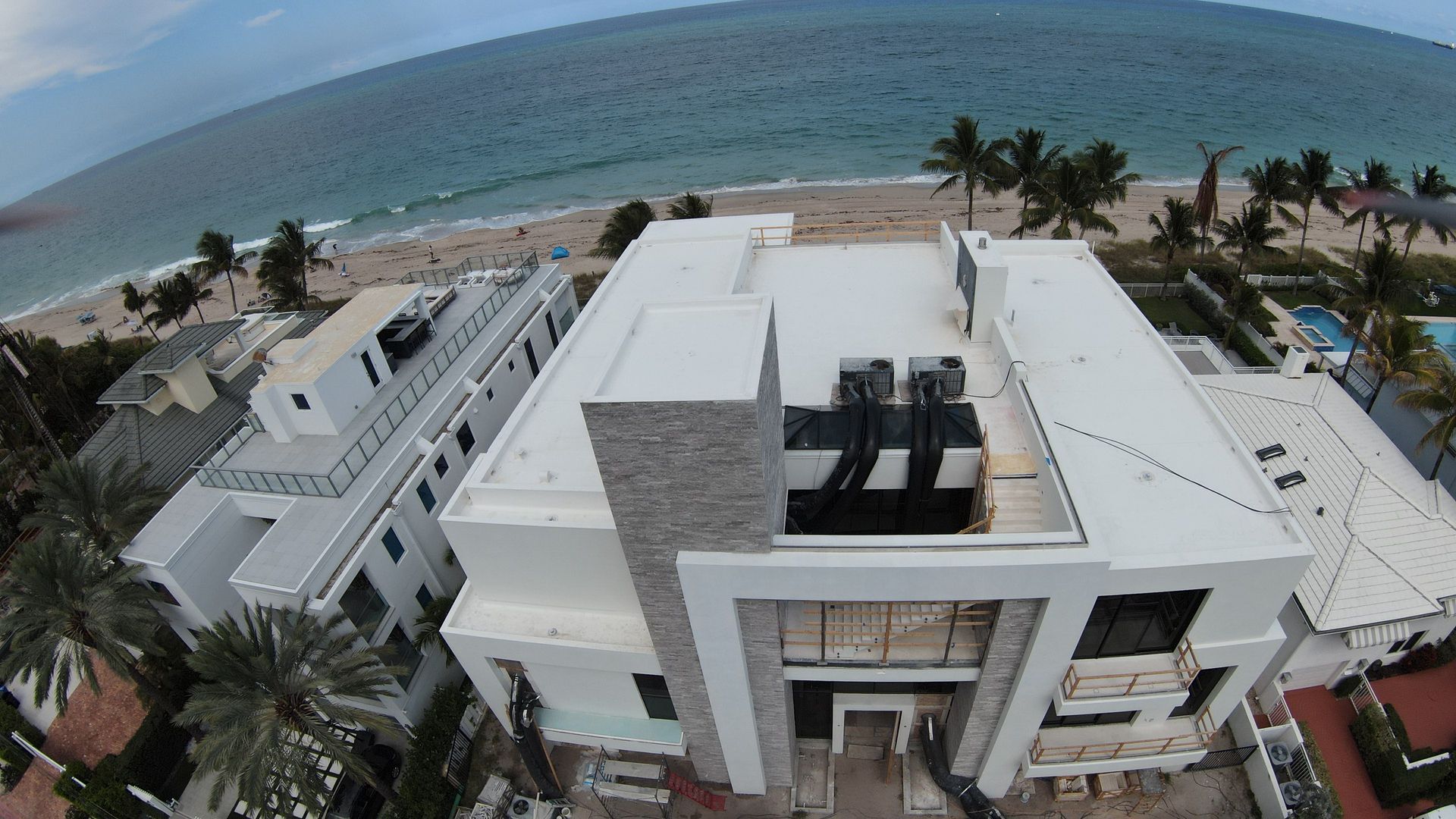 An aerial view of a large white building near the ocean