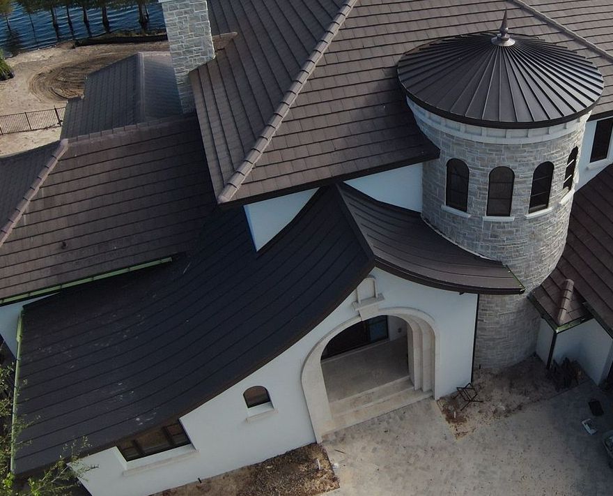 An aerial view of a large house with a brown roof