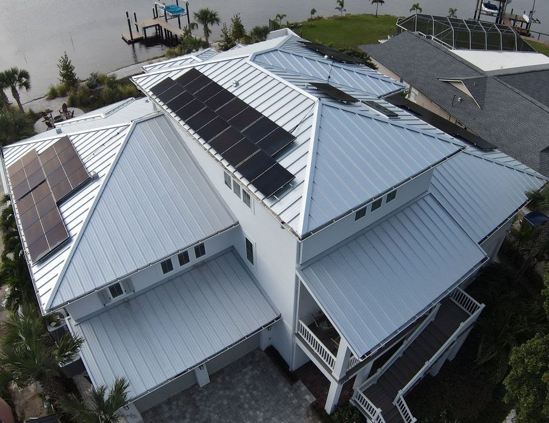 An aerial view of a house with solar panels on the roof