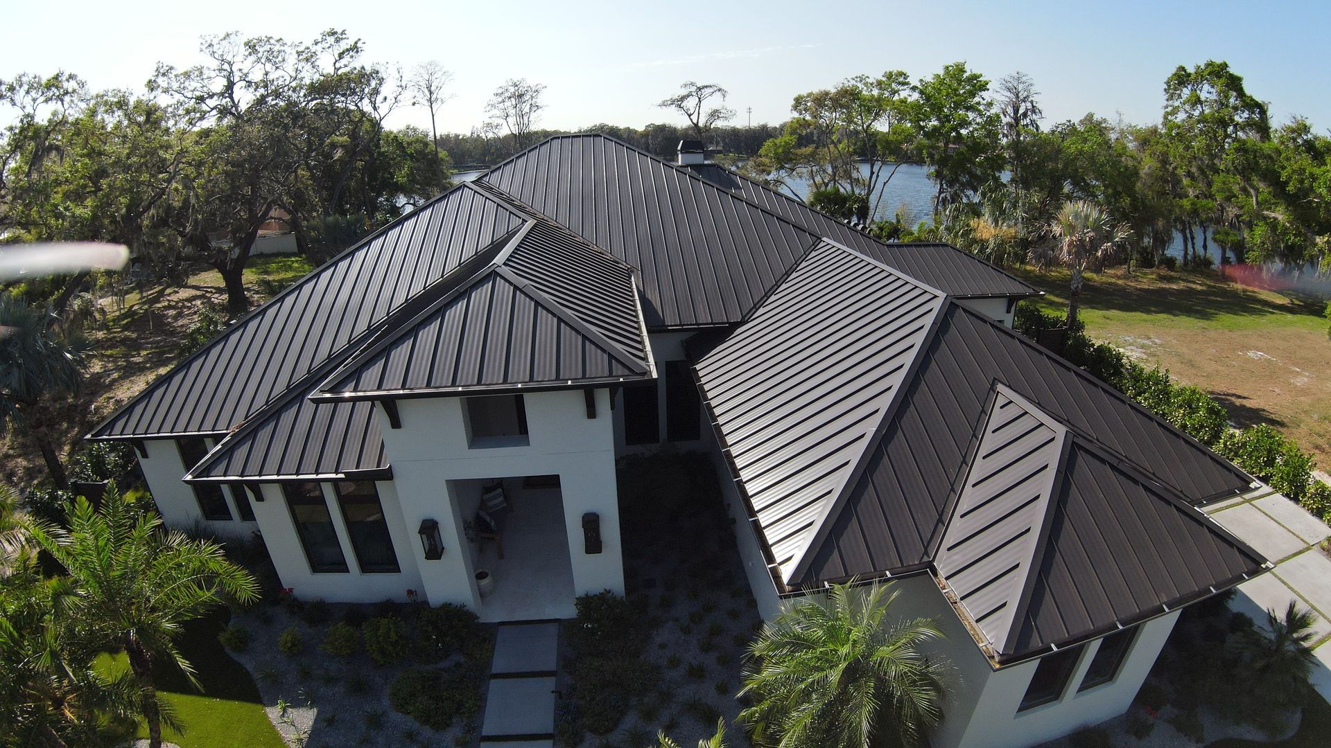 An aerial view of a large house with a black roof