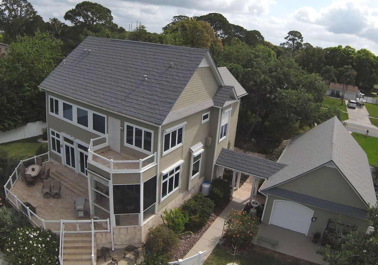 An aerial view of a large house with a gray roof