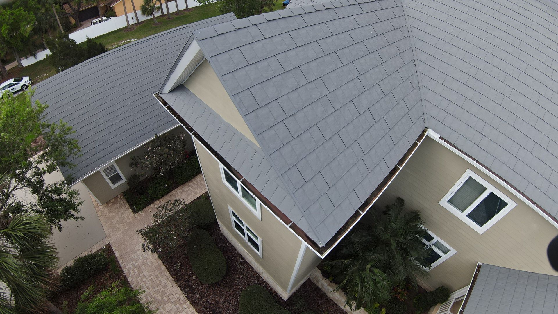 An aerial view of a house with a gray roof