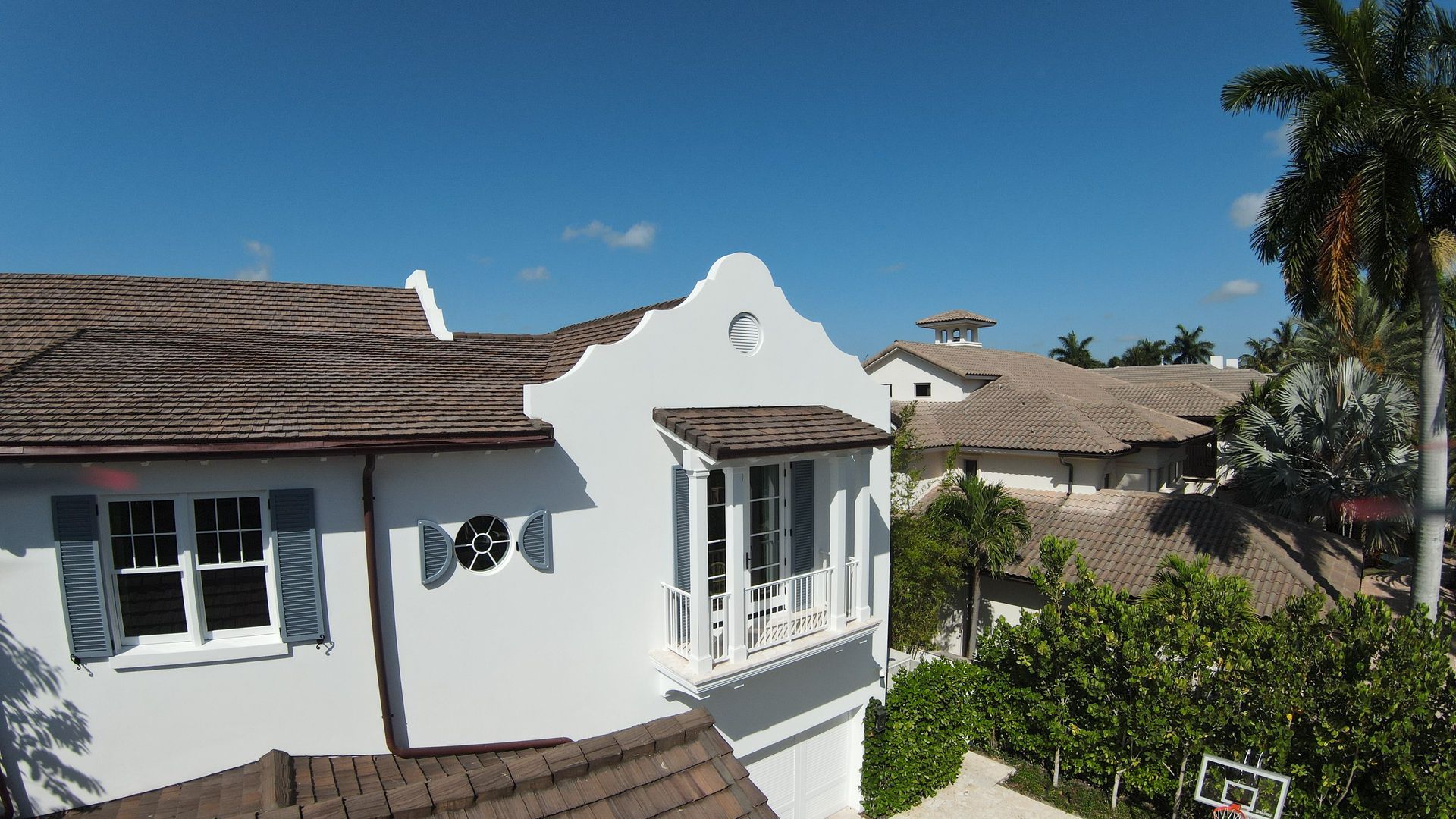 An aerial view of a white house with a thatched roof