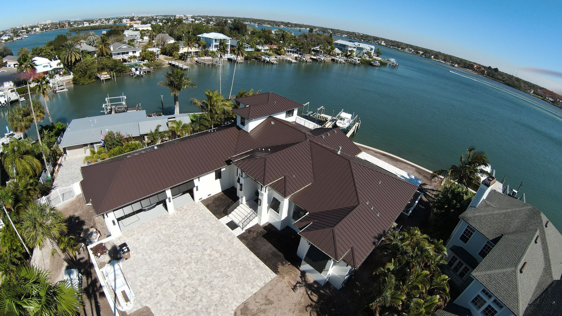 An aerial view of a house next to a body of water