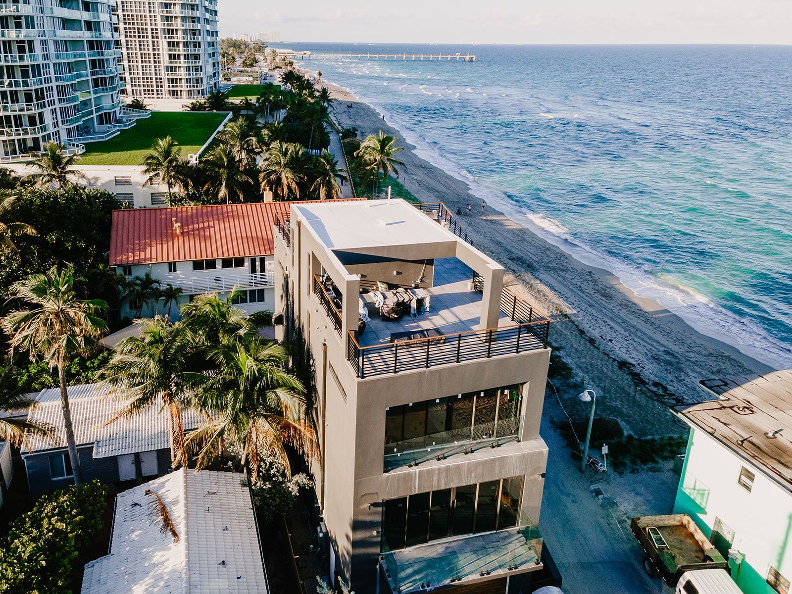 An aerial view of a house on the beach next to the ocean.