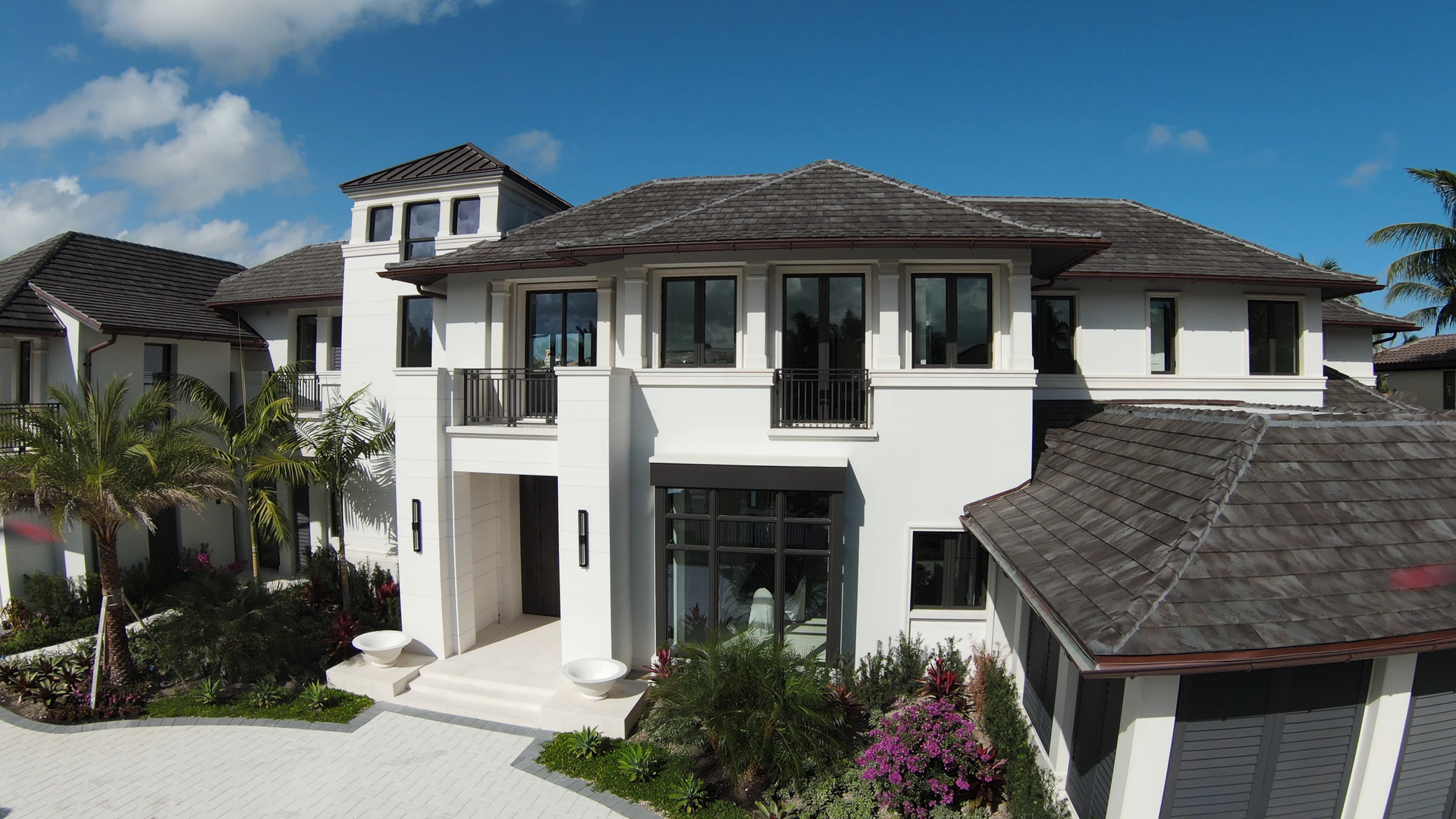 A large white house with a gray roof and a lot of windows