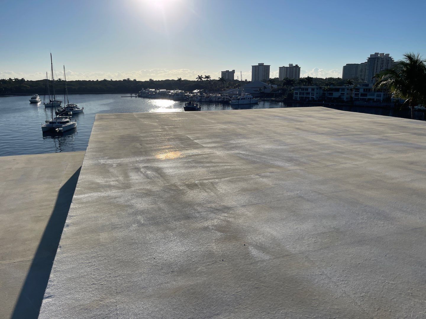 A dock with boats in the water and a city in the background