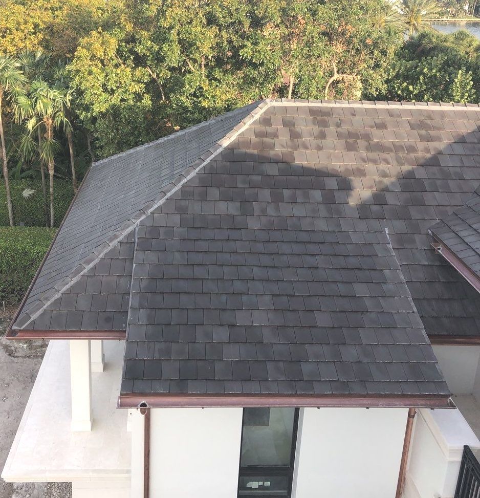 An aerial view of a house with a black roof