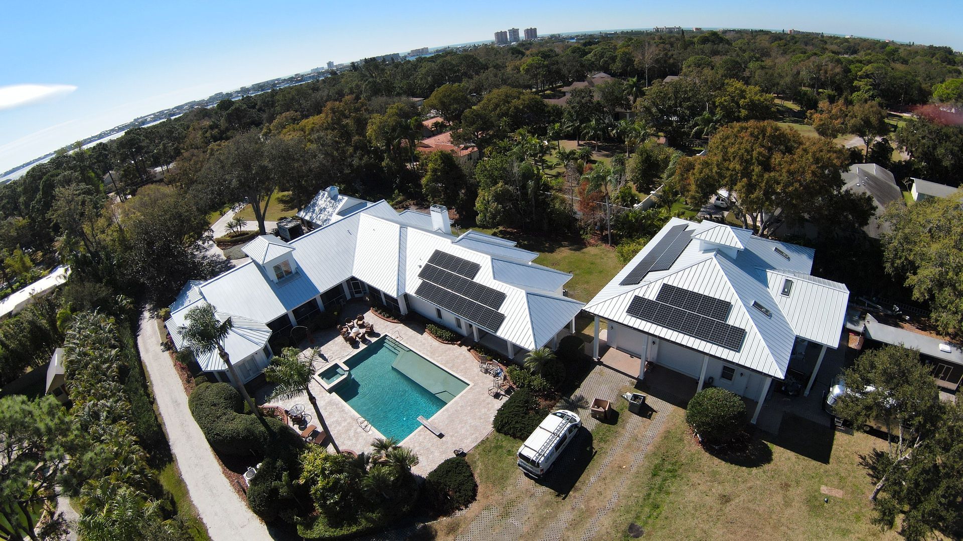 An aerial view of a house with a pool and solar panels on the roof