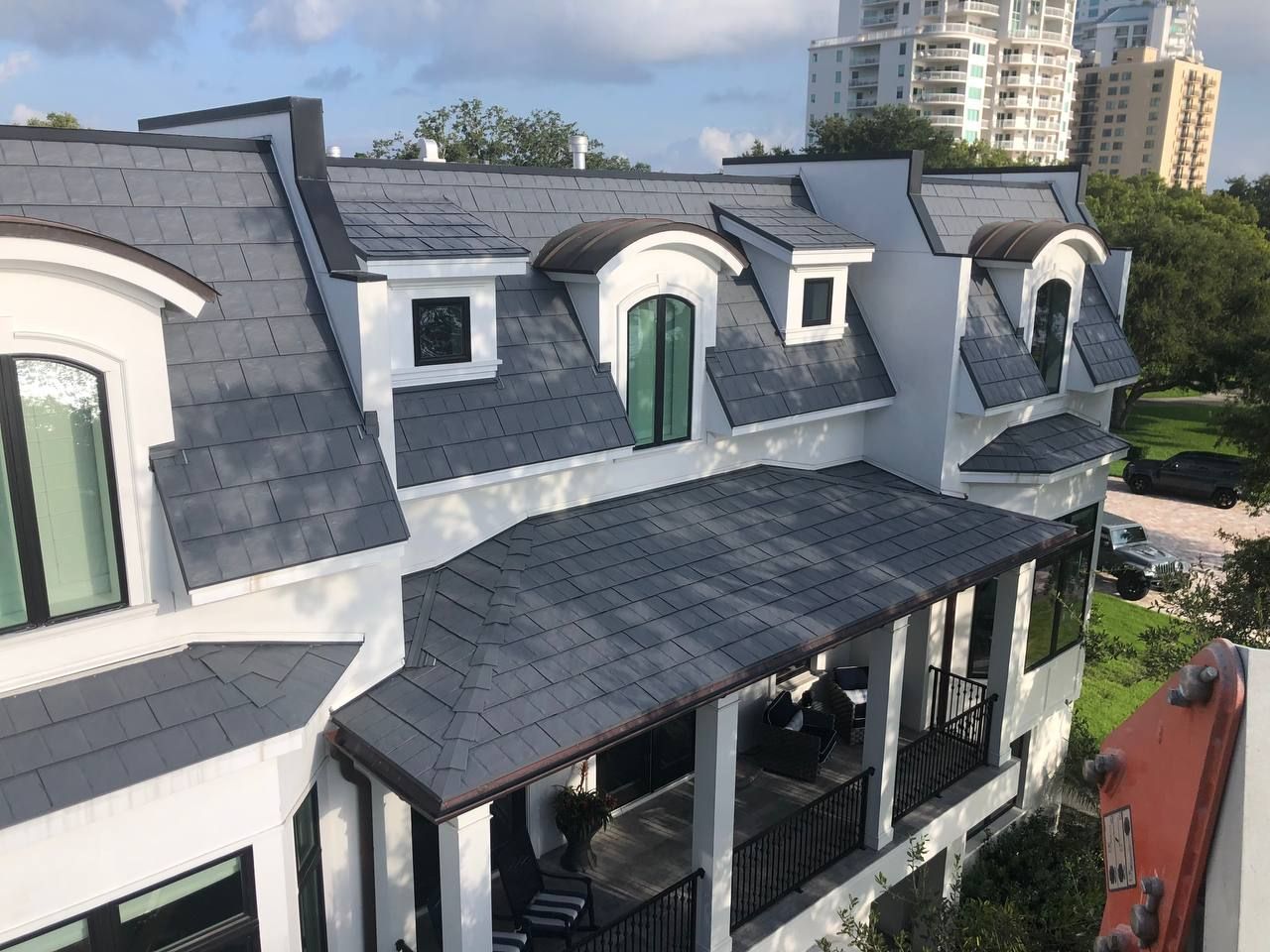 An aerial view of a white house with a slate roof.