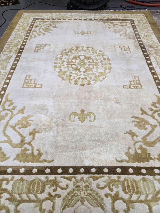 Beige and gold oriental rug with a central medallion and corner floral designs.