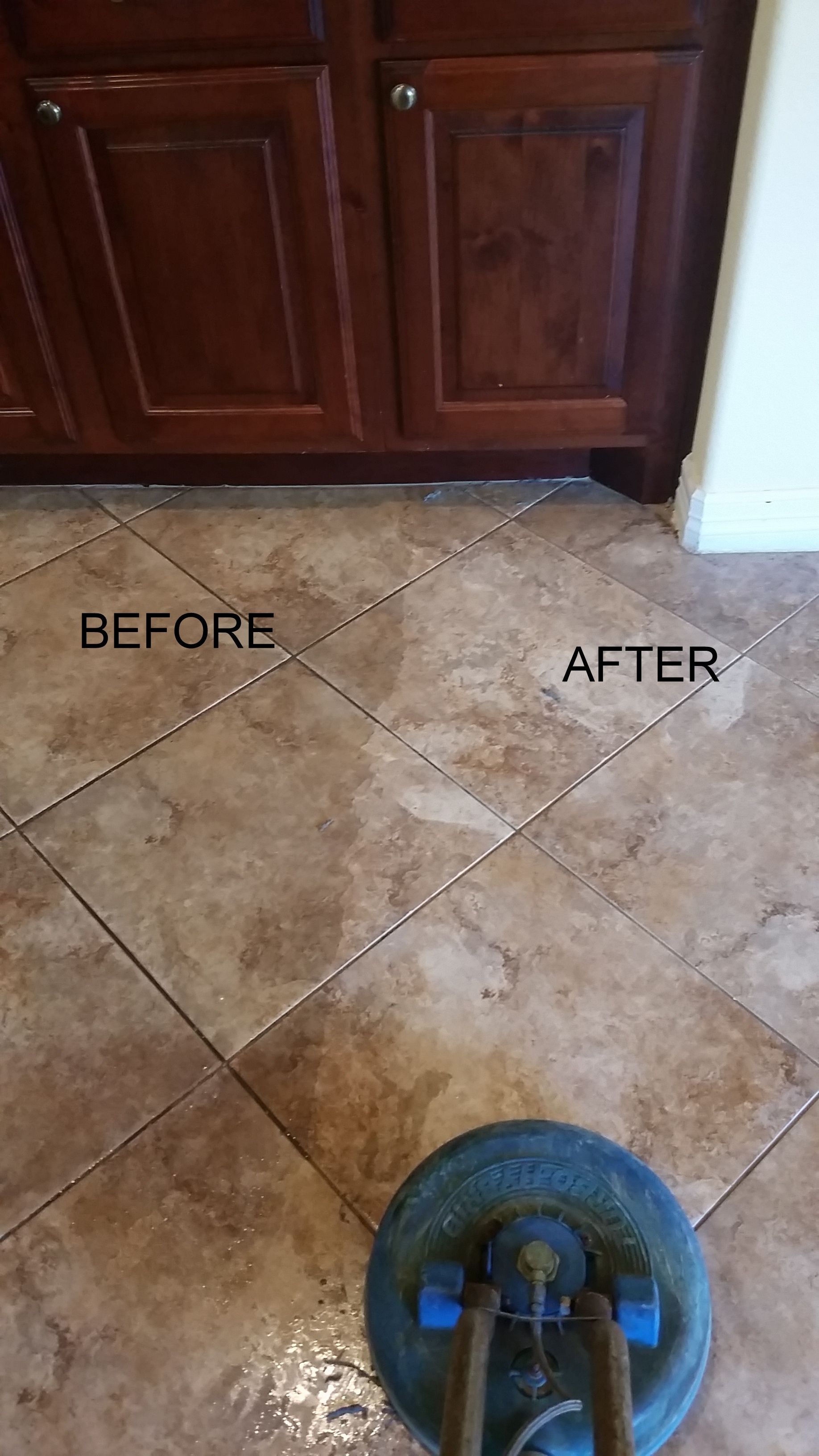 Before-and-after shot of tile floor cleaning. Brown tile floor with a cleaning machine. Dark brown cabinets above.