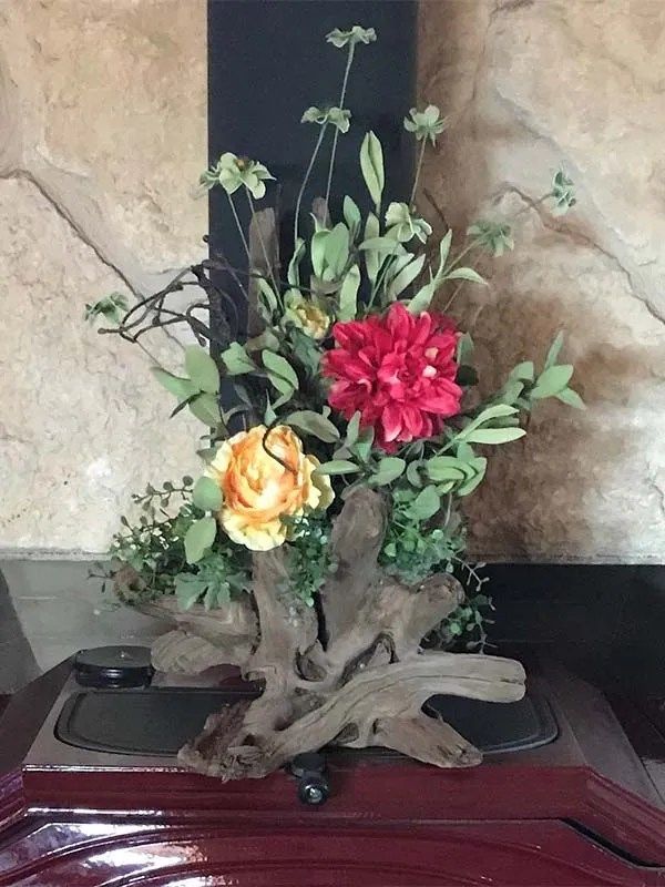 A vase of flowers is sitting on a table next to a speaker