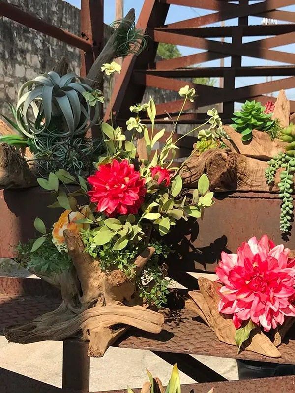 A bunch of flowers are sitting on top of a wooden table.