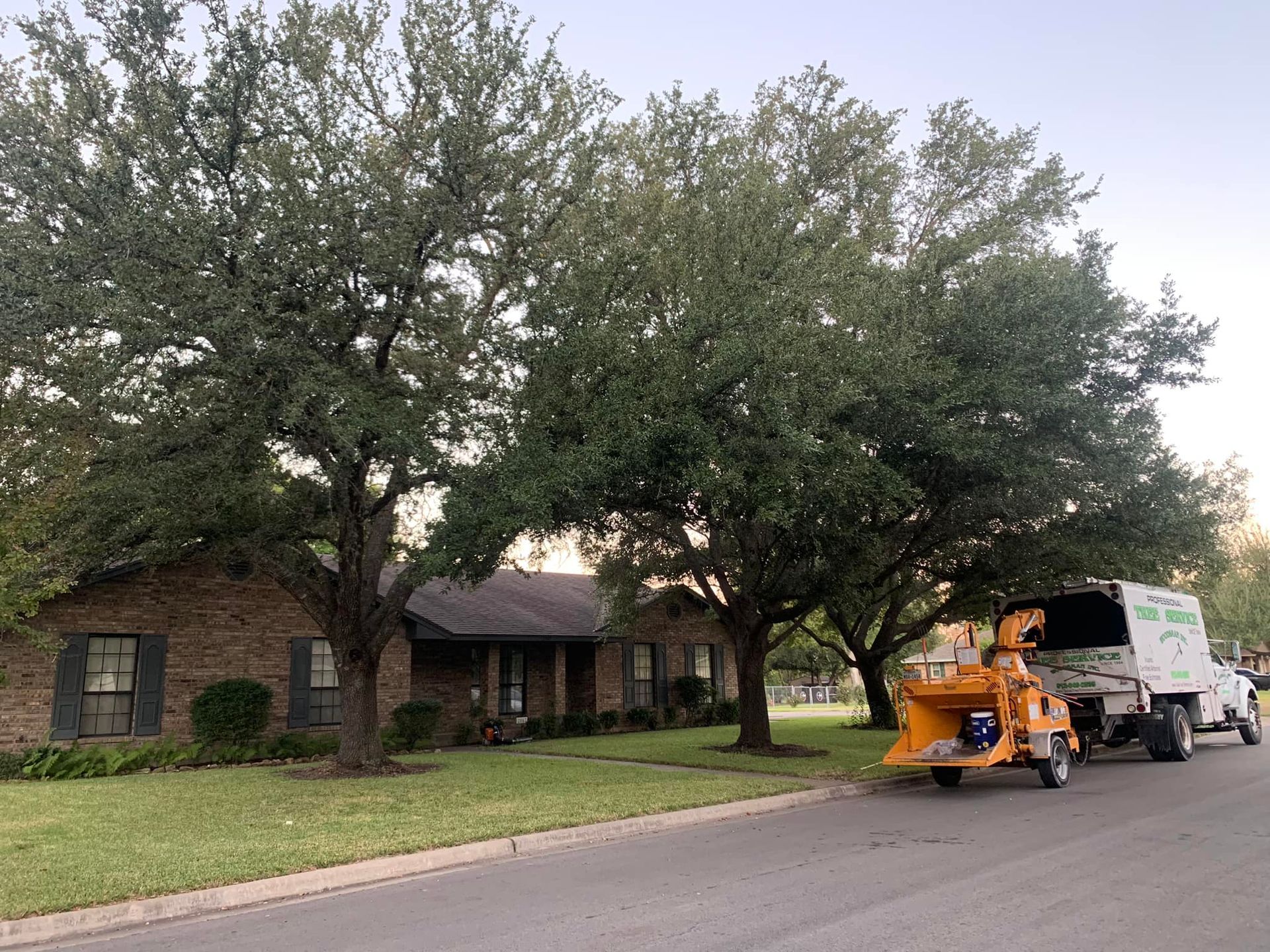 A tree chipper is parked in front of a house.