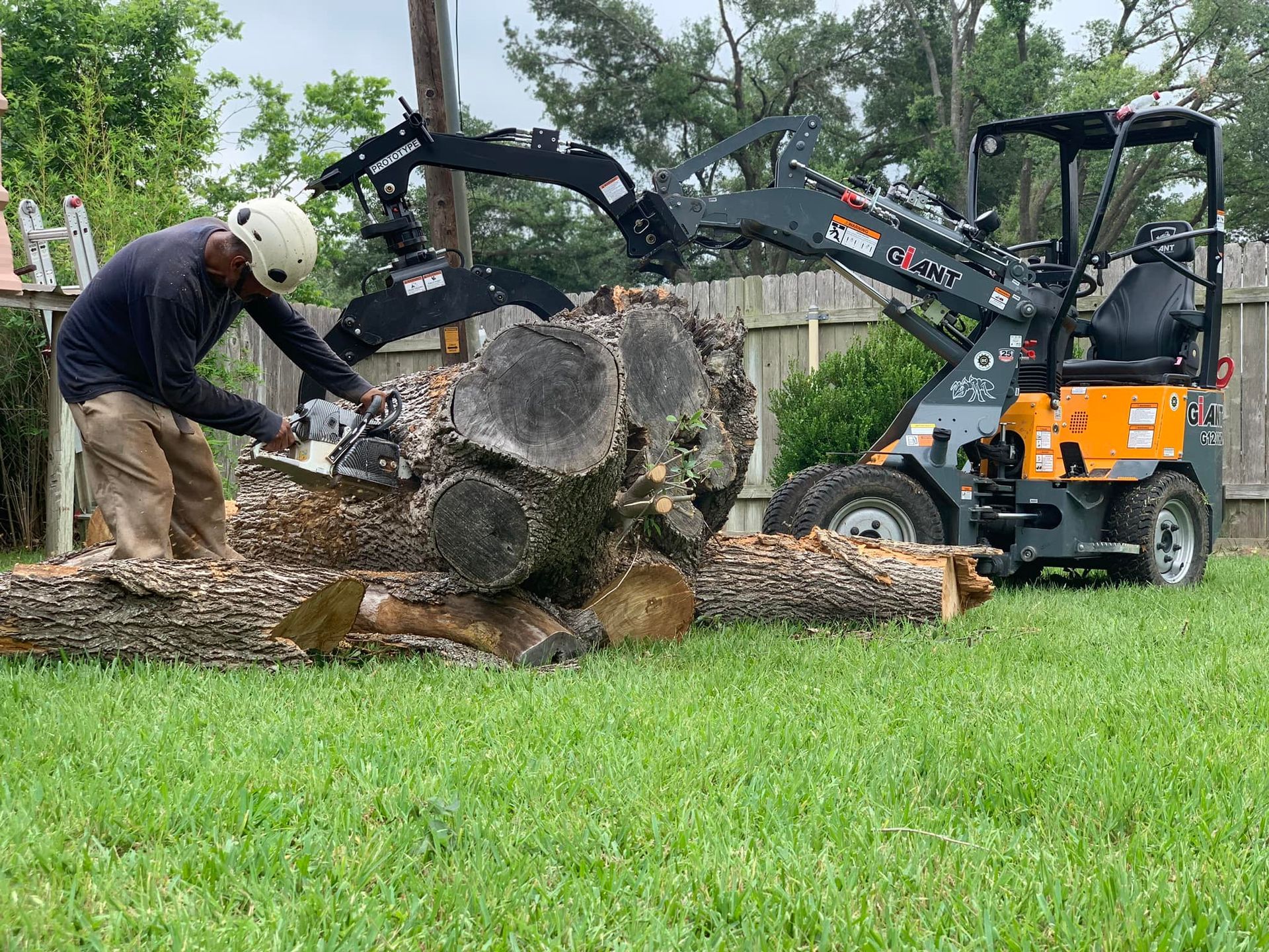 A man is cutting a large log with a chainsaw.