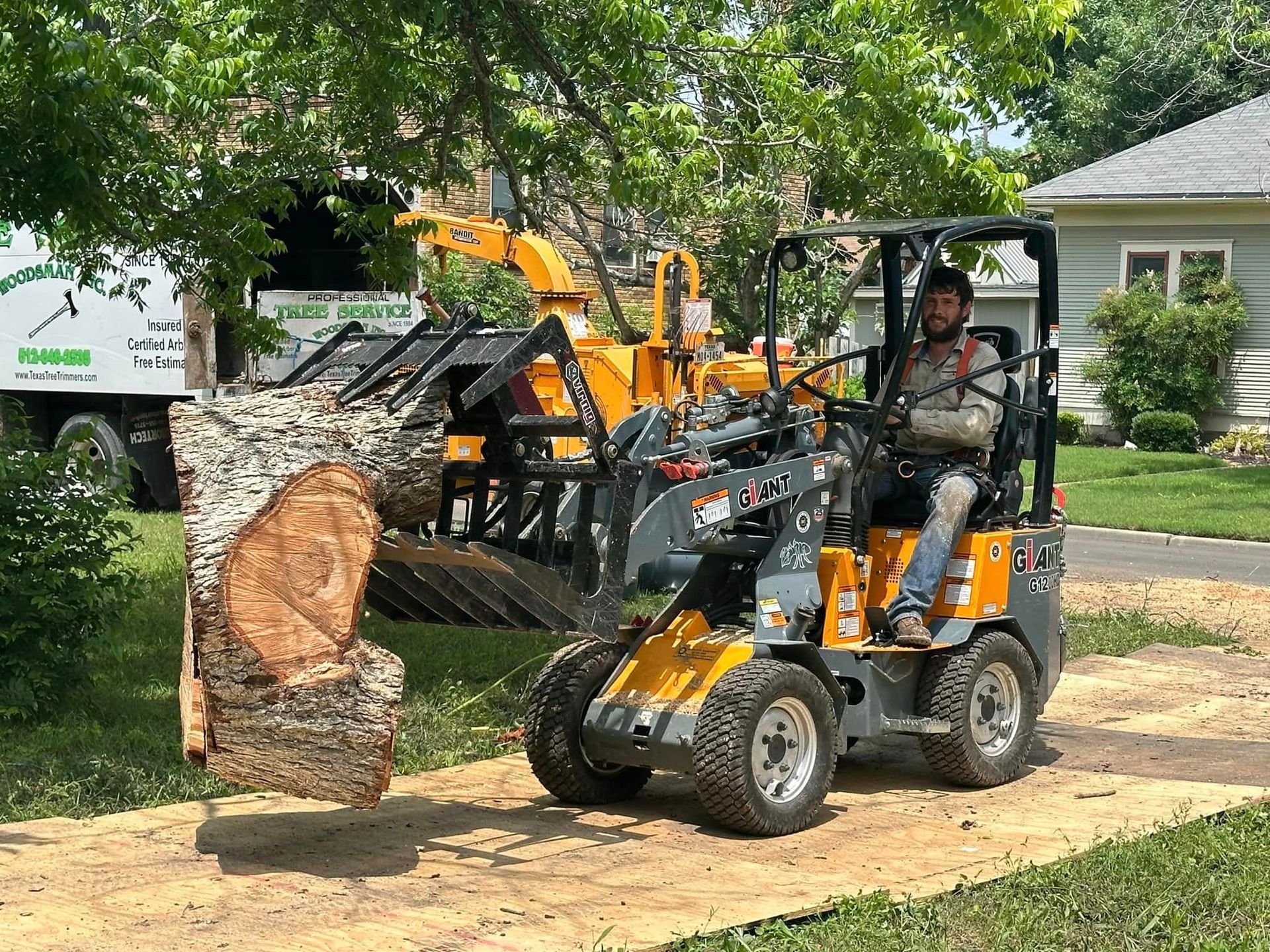 A man is driving a tractor next to a tree stump.