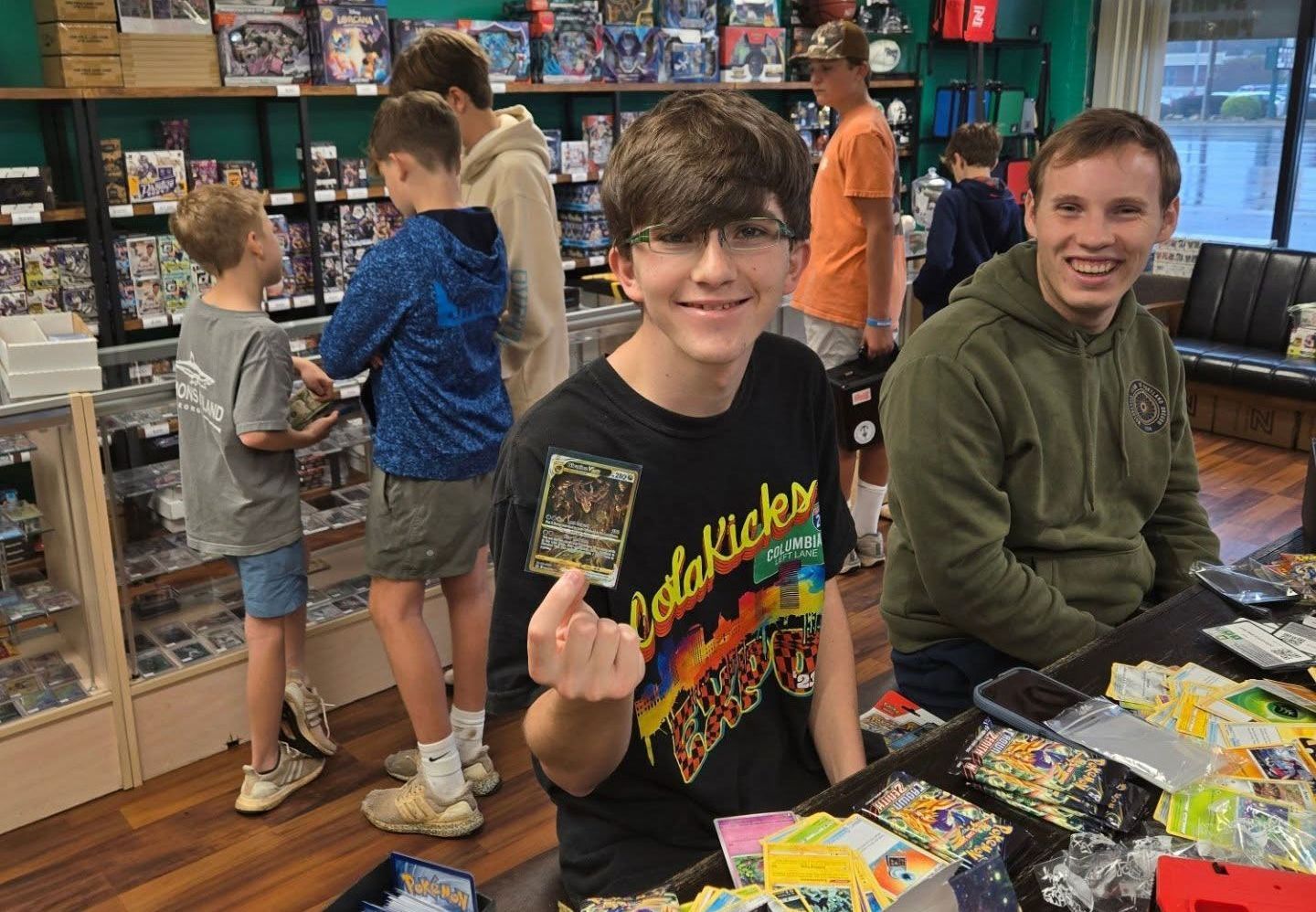 A boy is holding a card in his hand in a store.