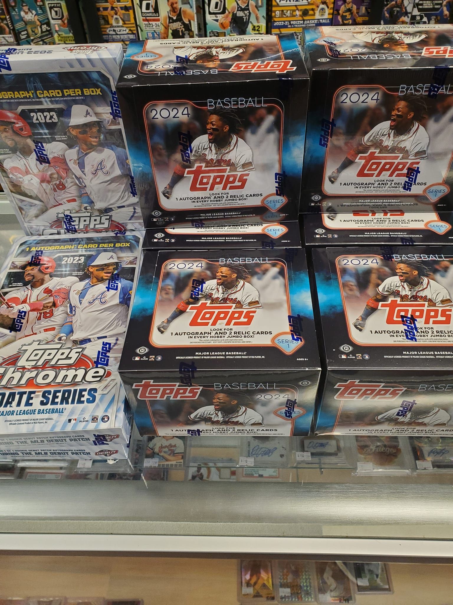 Boxes of topps baseball cards are stacked on top of each other on a shelf.