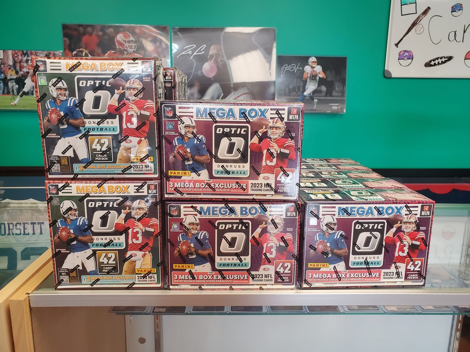 Several boxes of optic football cards are stacked on top of each other on a table.