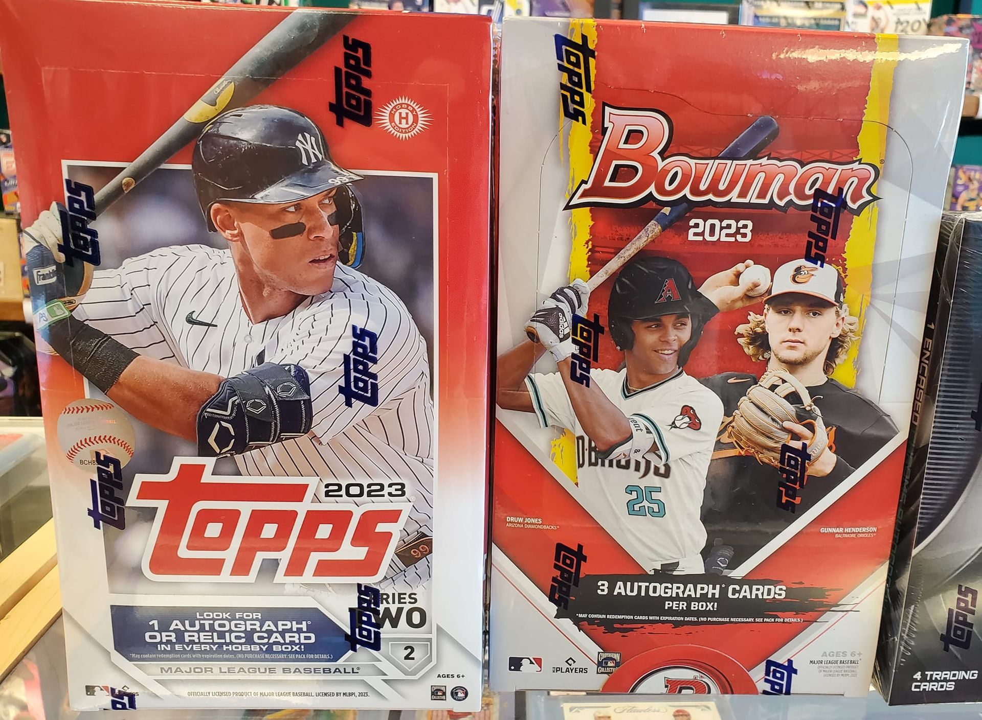 Two boxes of topps baseball cards are on display in a store.