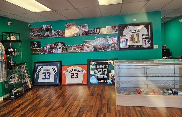 A room with a lot of framed baseball jerseys on the wall