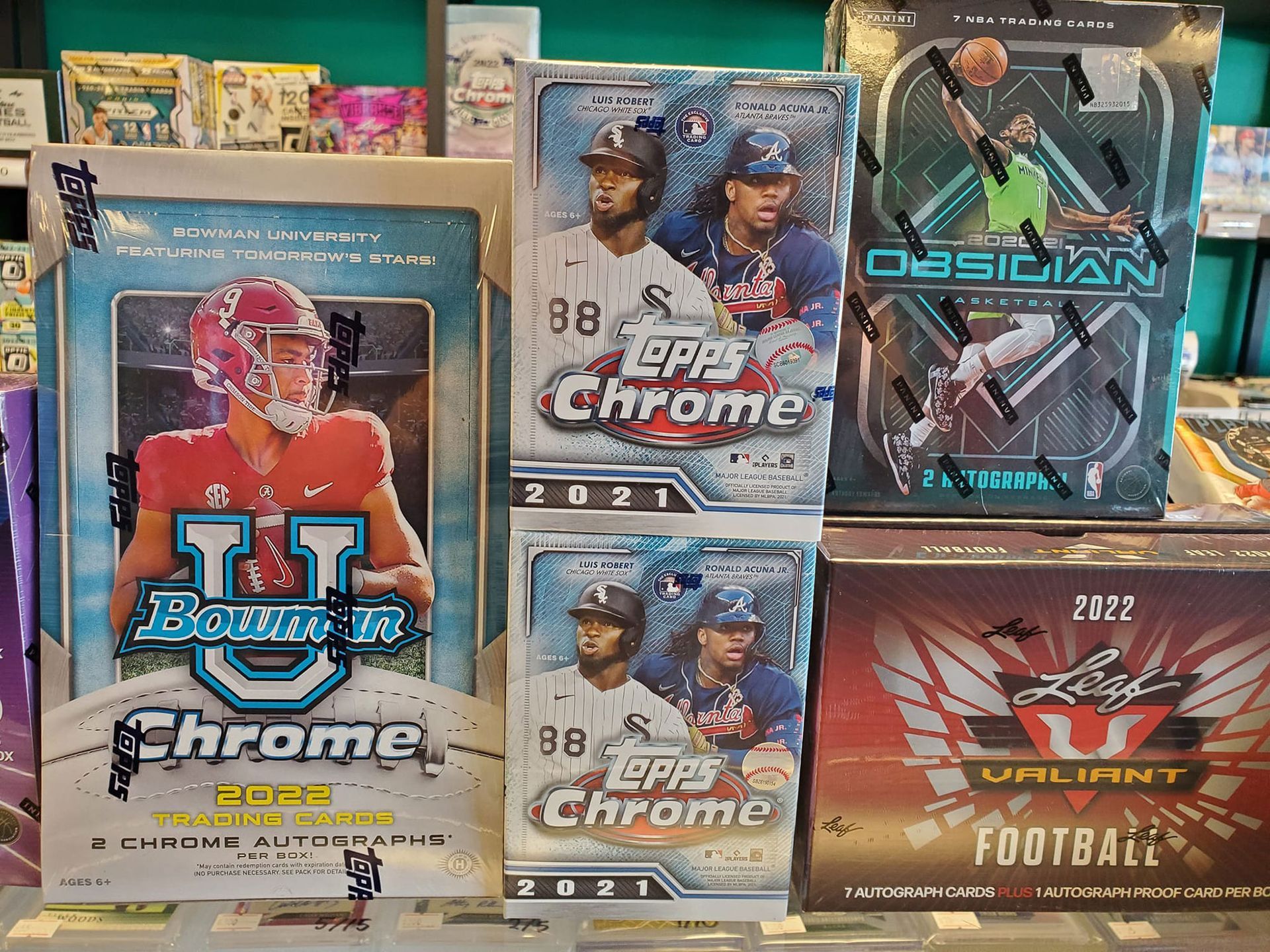 A bunch of baseball cards are stacked on top of each other on a shelf.