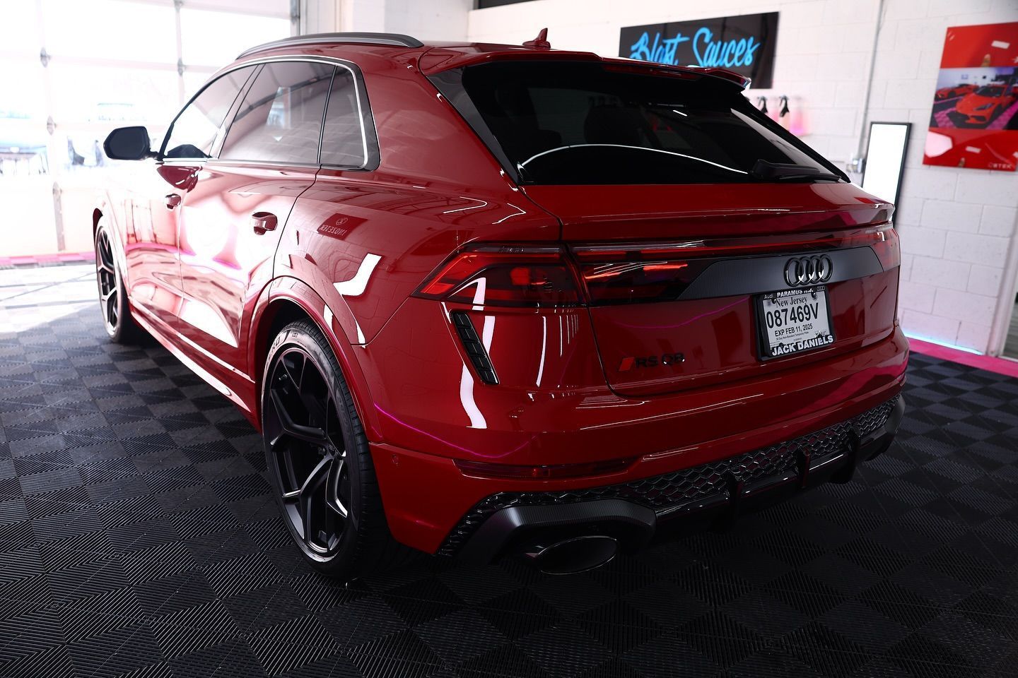 Red Audi SUV parked indoors with black wheels and tinted windows.