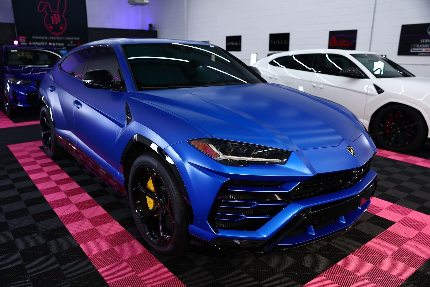 Blue Lamborghini SUV with black accents and yellow brake calipers.