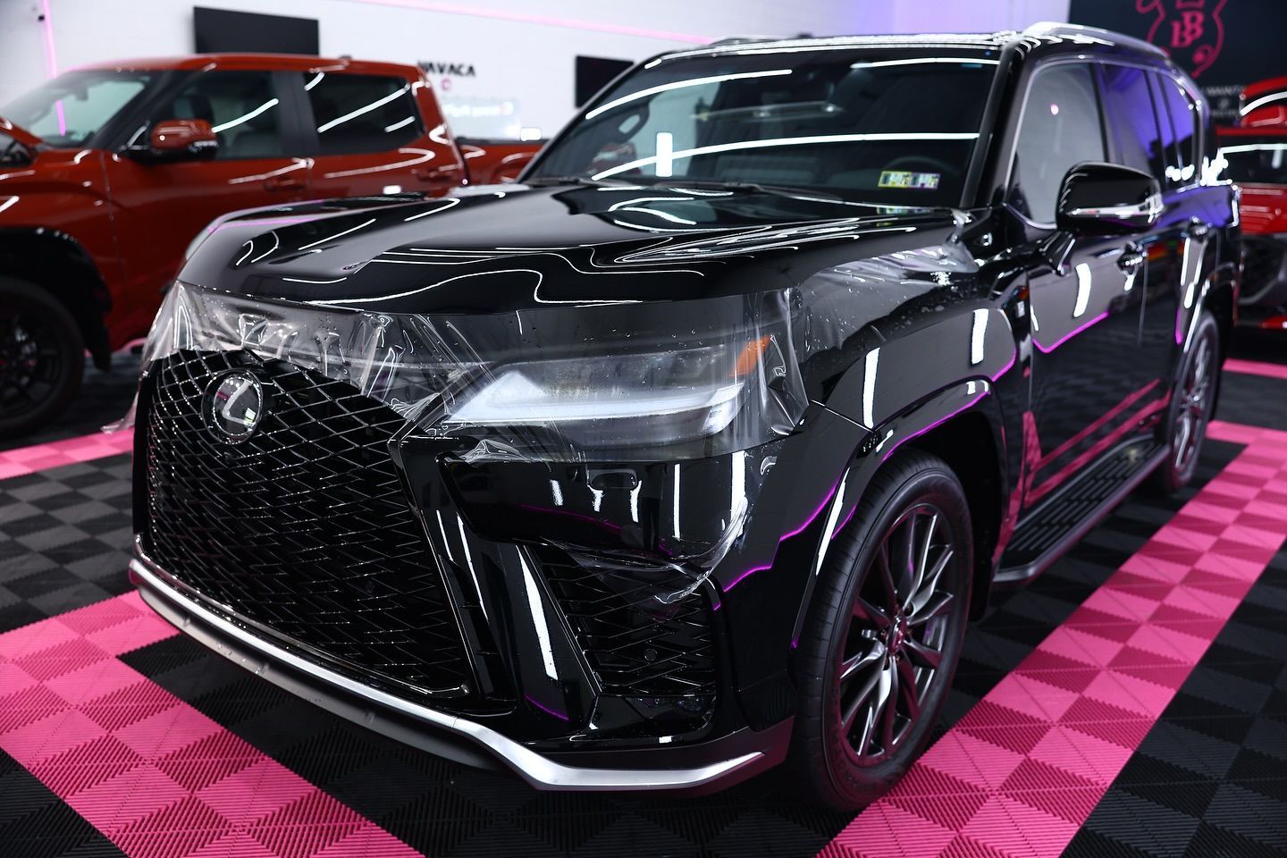 Black Lexus SUV on a patterned floor, covered front.