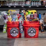 Two red buckets filled with cleaning supplies are sitting on a table.