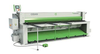 A green and white machine is sitting on top of a white table.