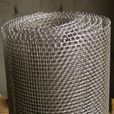 A roll of wire mesh is sitting on top of a wooden table.