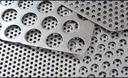 A close up of a perforated metal sheet with holes in it.