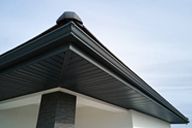 A close up of the roof of a house with a black gutter.
