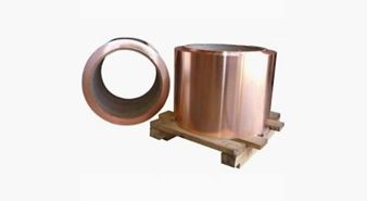 A roll of copper foil is sitting on top of a wooden pallet.