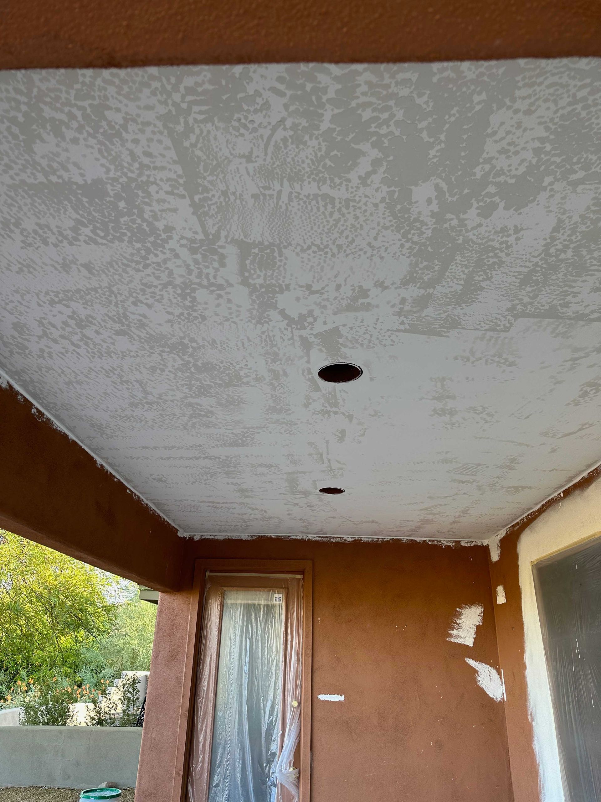 A porch with a ceiling that is covered in white paint.