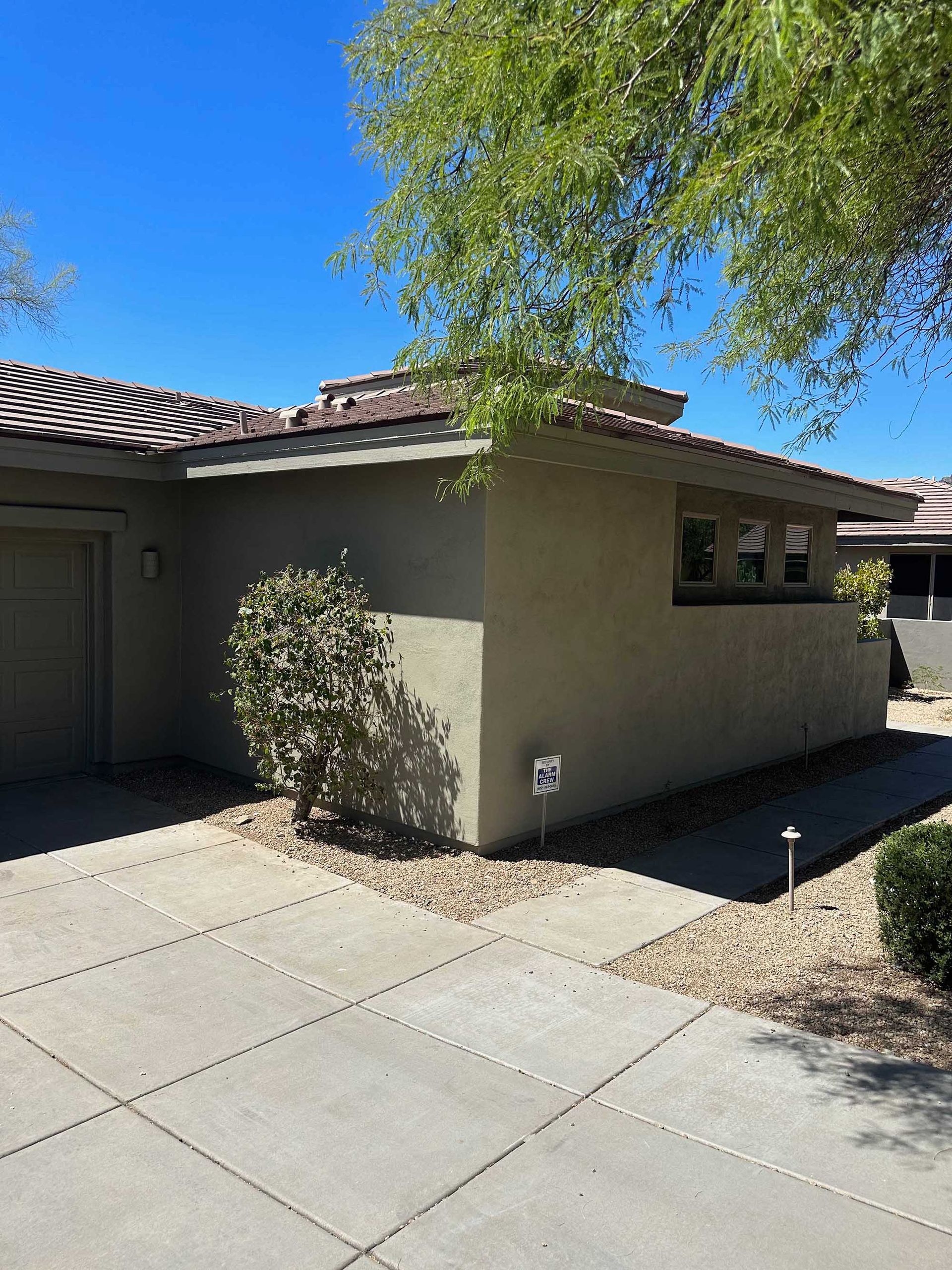 A house with a garage and a tree in front of it